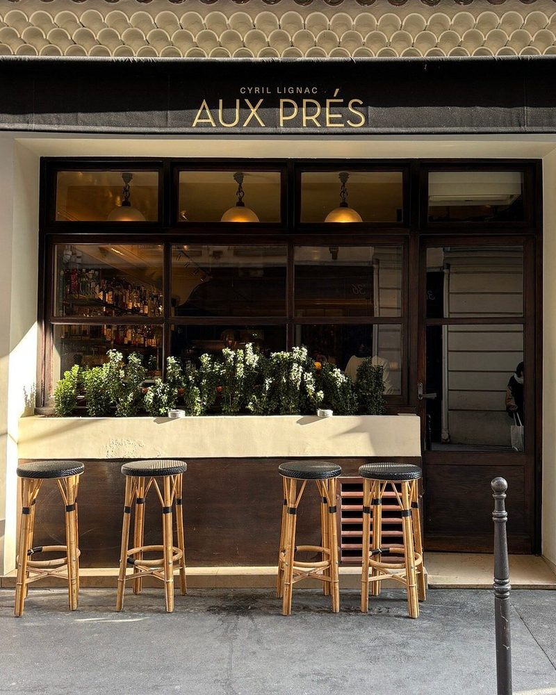 La devanture du restaurant Aux Prés, à Paris, sous son enseigne dorée « Cyril Lignac — Aux Prés »